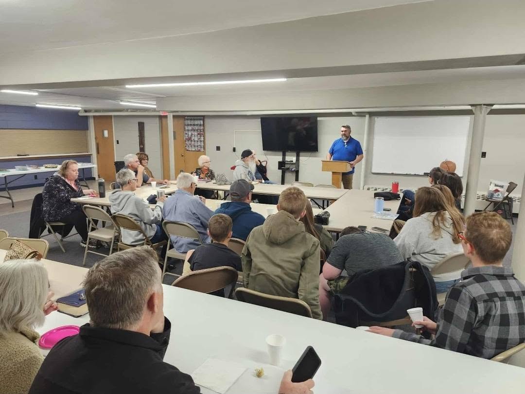 Tim Carmical teaching adults gathered around tables in a church classroom