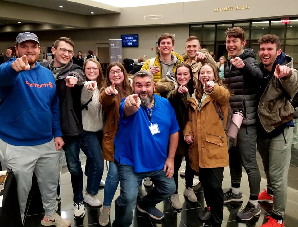 Tim Carmical surrounded by a group of smiling college students